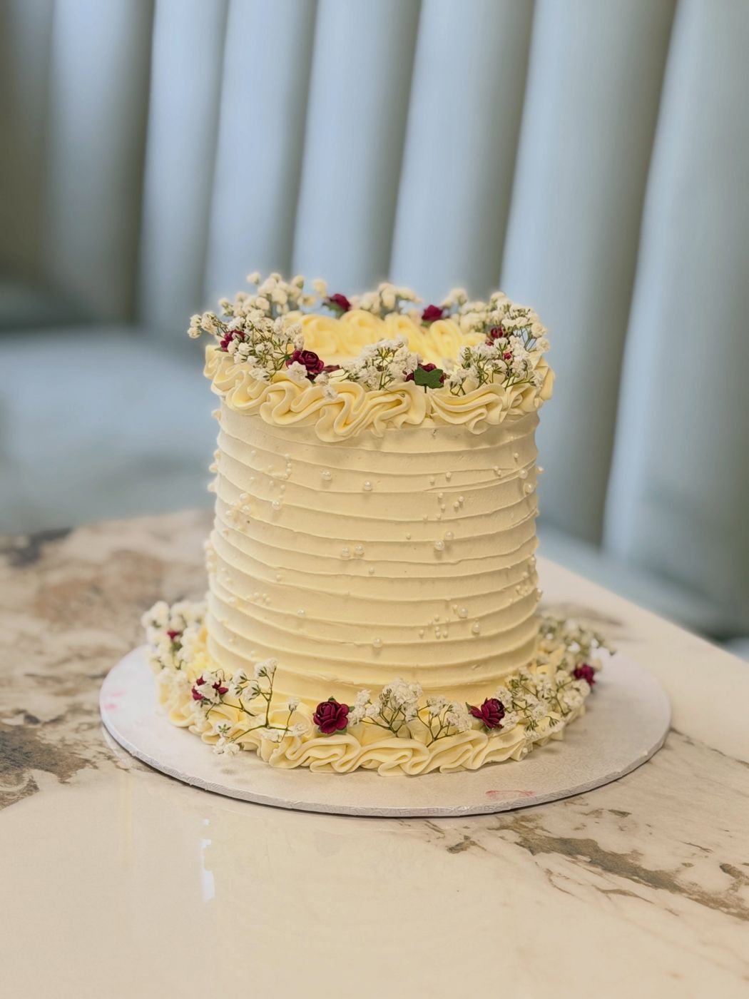 A cream celebration cake with berries at MBaked Sheffield