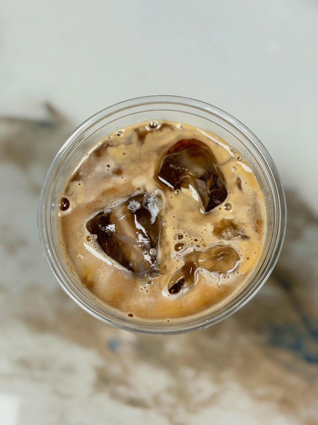 An iced coffee from above on marble